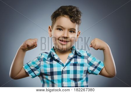 Closeup Portrait of Funny Little child. Sport Handsome Boy. Strong serious kid showing his hand biceps muscles.