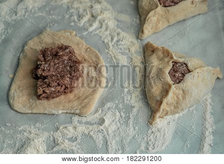 Baking peremech concept. Flour, dough and meat cooking ingredients. ground meat with hole