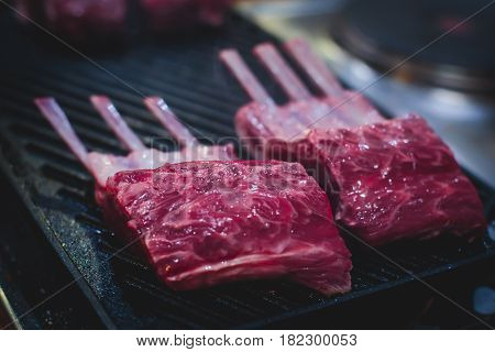 Different stages of cooking the steak on a kitchen, barbeque, roasted lamb ribs, big dish plate with roasted full pork head, served in restaurant with vegetables, lamb, ham and chicken.