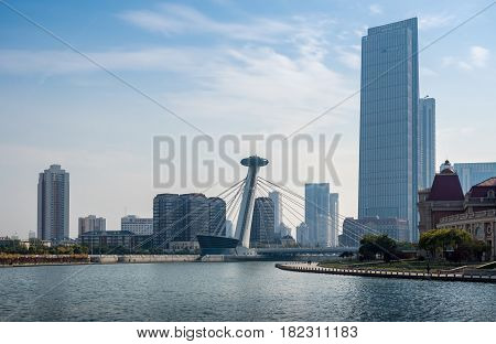 Tianjin, China - Nov 1, 2016: Chingfen Bridge spans across the Haihe River. Backgropund buildings in contrasting modern and old architectural style. Viewed from Tianjin Railway Station.