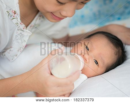 Sister takecare asian new born baby to sleep in thr cradle