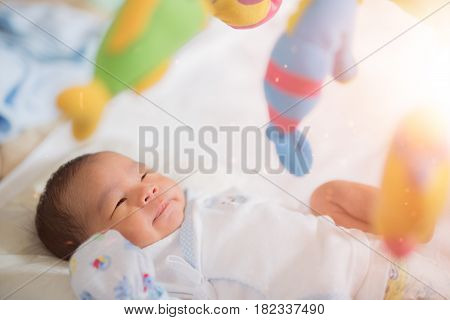 Baby sleep in cot with over head fish mobile