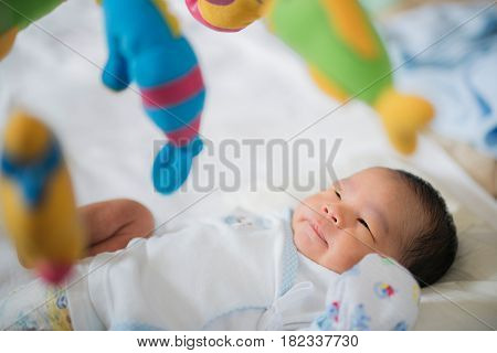 Baby sleep in cot with over head fish mobile