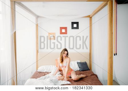 Beautiful Naked Pretty Sensual Brunette Girl Sitting On The Bed And Looking Out The Window At The Mo
