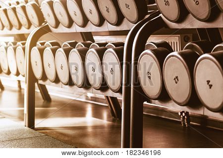 Rows of dumbbells in the gym with hign contrast and monochrome color tone