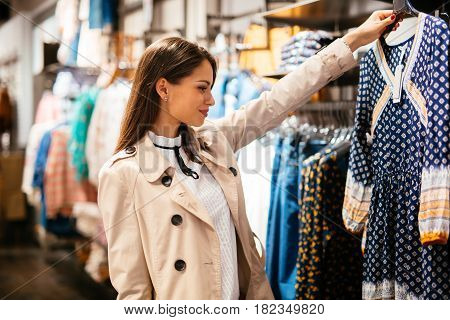 Beautiful young businesswoman buying clothes in boutiqe