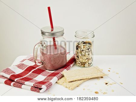 Strawberry smoothie with granola and crackerbreads for healthy breakfast. Healthy life style concept