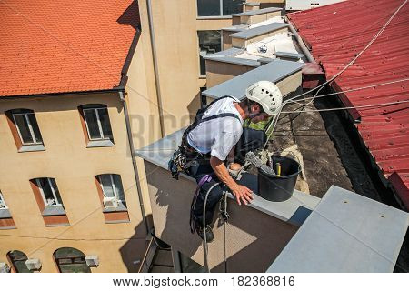 Young Window Cleaner Descend from the Roof of the Building. High Risk Work.