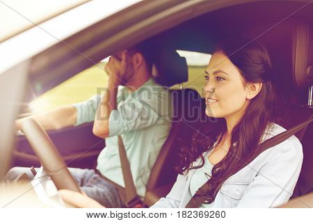 leisure, road trip, travel and people concept - woman driving car and man covering face with his palm