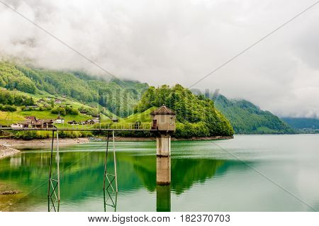 Beautiful emerald mountain lake Lungern in Switzerland under low clouds