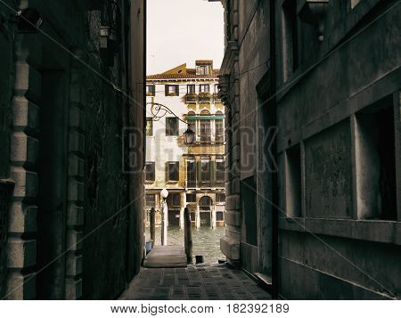 Narrow passage in Venice streets leading to water
