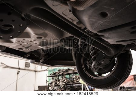Close up of below of a car for examining tire at the garage.