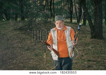 Outdoor portrait of severe senior ranger with two rifles