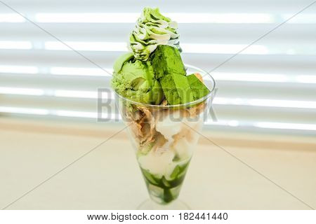 Green Tea Ice cream with Vanilla Soft Cream and Green tea chocolate garnished with Whipped cream and corn flake