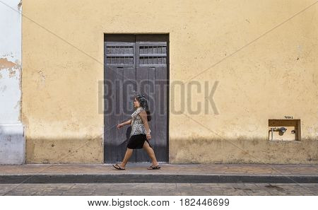valladolid Mexico 13th March 2017: a woman walking in front of an old colonial house