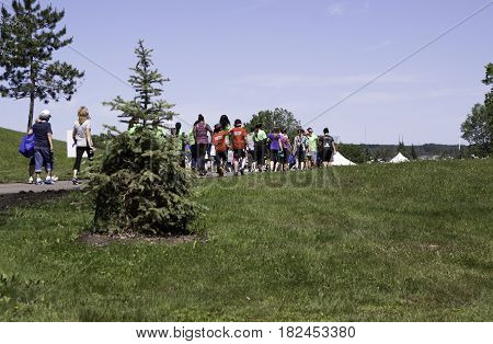 Laval, Quebec - June 14, 2015 - Landscape view from the back of people walking on a path towards the finish at the 