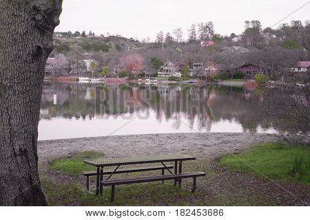 Picnic table at park with hilly mountainside with beautiful lake reflection