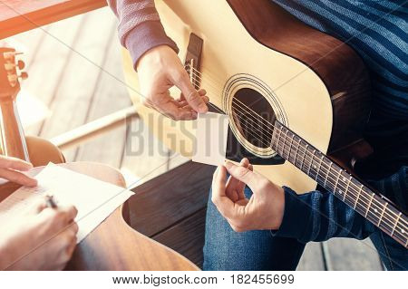 Masterclass learning to play the guitar outdoors. Musical education.
