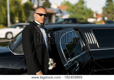 Handsom young man in tuxedo standing by his Limousine going out on the town