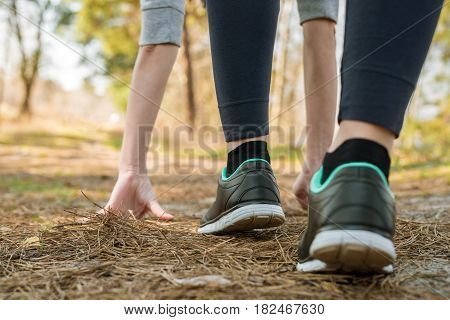 Girl In Sports Pants And Shoes, Stands At The Start Before Running, Leaning Hands, On The Nature.