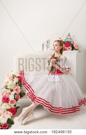 Pretty ballerina in stage costume holding a bouquet of spring flowers. Retro dress. She dreams.