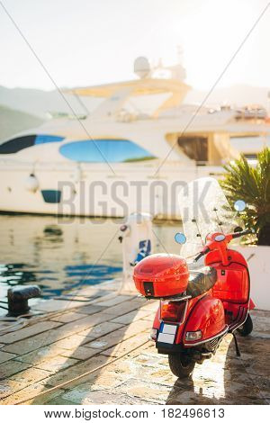 A red retro moped parked at the marina. In Budva, Montenegro