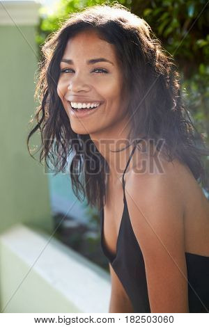 Young Latin American woman outdoors turns to camera smiling