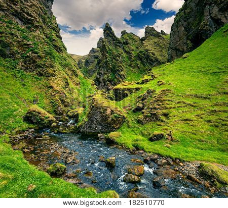 Tipical volcano Icelandic landscape in the mountains. Colorful summer view of green canyon with pure water creeck south Iceland Europe. Artistic style post processed photo.