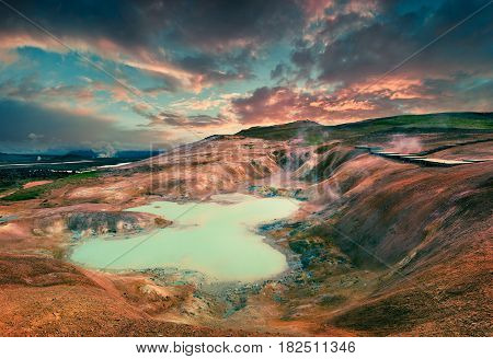 Boiling water lake in the Krafla volcano. Colorful exotic sunset with lava ground in the geothermal valley Leirhnjukur located near Lake Myvatn in north of Iceland Europe. Artistic style post processed photo.