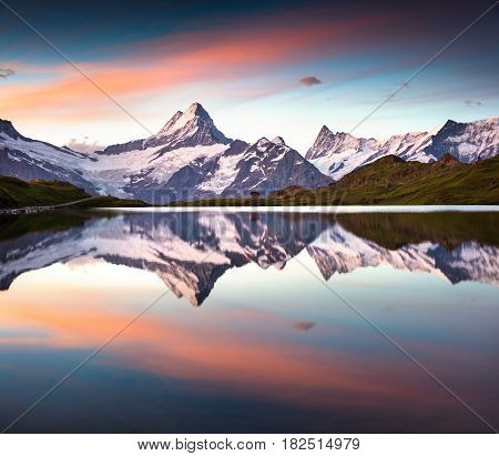 Wetterhorn peak reflected in water surface of Bachsee lake. Colorful summer sunrise in Bernese Oberland Alps Grindelwald location Innertkirchen Switzerland Europe.