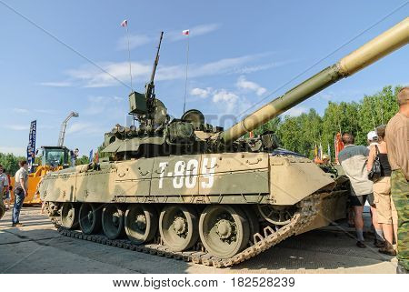 Nizhniy Tagil, Russia - July 12. 2008: Visitors examine military equipment on exhibition range. T80U modernized tank. Russian Arms Expo