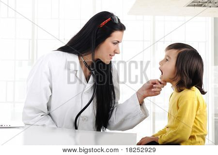 Kadın doktor inceleyerek çocuk dil depressor ile