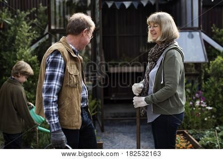Senio rcouple with little boy gardening at home backyard