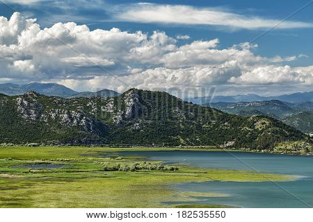 Panoramic view of Skadar lake at the Montenegro part travel destination. A sunny day in the Skadar lake bay national park and one of the beautiful places on Montenegro, Europe. Close-up of a mountain
