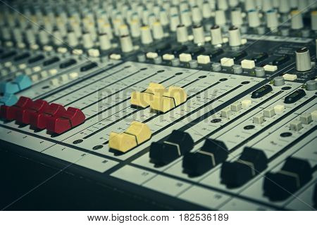 Music mixing console with backlit buttons. Audio mixer mixing board fader and knobs