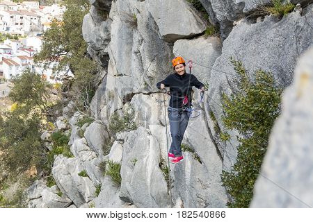 Woman hanging on Tibetan bridge climbing up to the hill. Horizontal outdoors shot