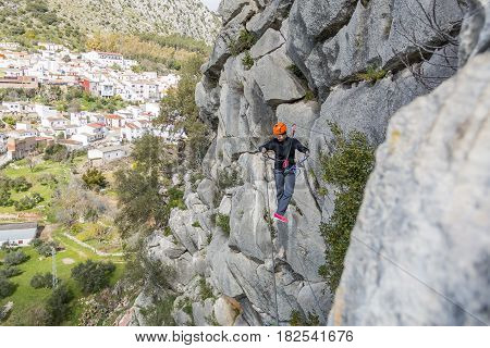 Woman hanging on Tibetan bridge climbing up to the hill. Horizontal outdoors shot