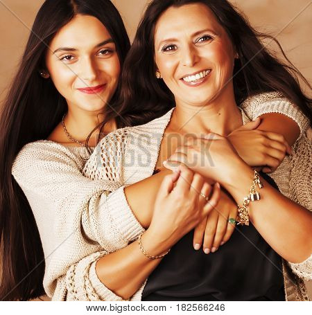 cute pretty teen daughter with mature mother hugging, fashion style brunette makeup close up, real happy family