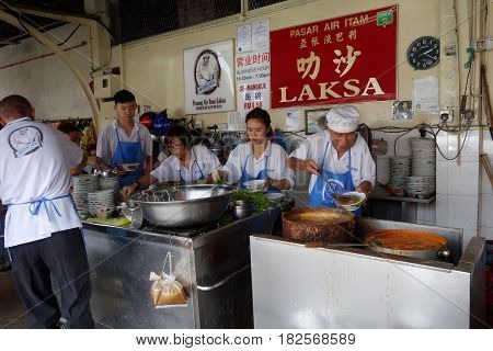 Hawker Vendor At Their Assam Laksa Noodle Stall In Air Itam, Penang