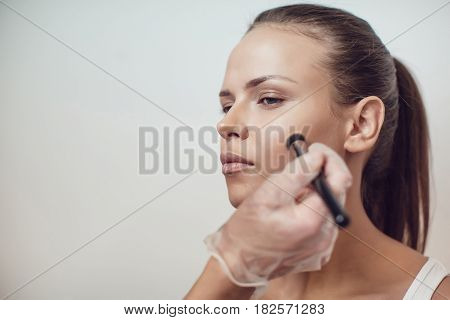 Professional make-up artist makes makeup of model. Beauty and fashion concept. Close up.
