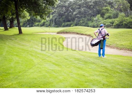 Golfer carrying his equipment on a beautiful sunny day