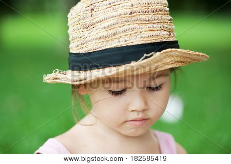 Girl in a straw hat in the park
