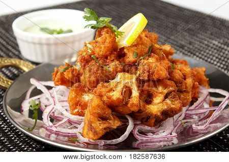 Cauliflower in battered onion with pickled onion isolated on white background