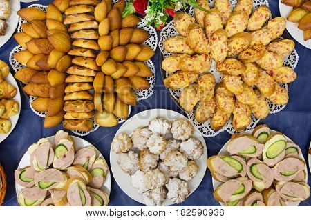 Set of sandwiches biscuits cakes and patties on blue table