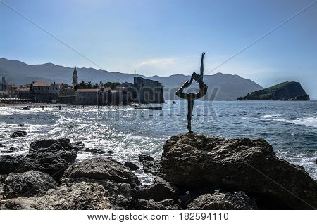 Dancing Girl Statue - an attractive sculpture and popular photo opportunity for tourists on background of old city Budva