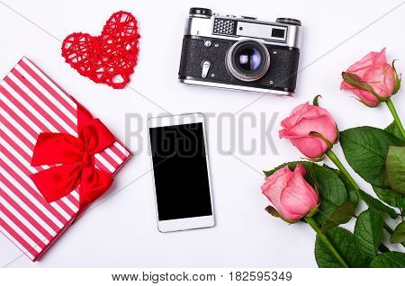 Romantic Concept On White Background: Roses, Smartphone And Old Camera.