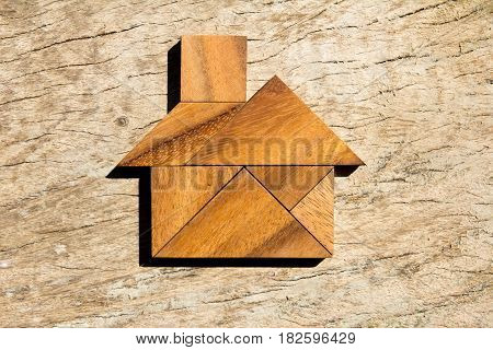 Wooden tangram puzzle in home shape for dream home or happy life concept