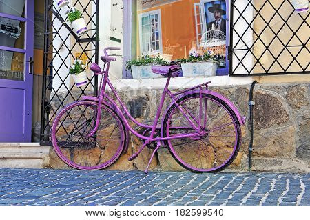 SZENTENDRE HUNGARY - MAY 25: Purple bike standing in front of souvenir shop in Szentendre on May 25 2016. Szentendre is a small touristic town located 30 minutes from Budapest.