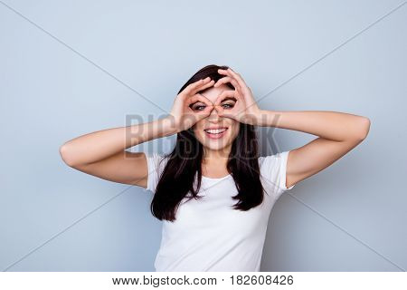 Attractive Young Laughing Woman Having Fun And Making Binoculars Using Her Hands