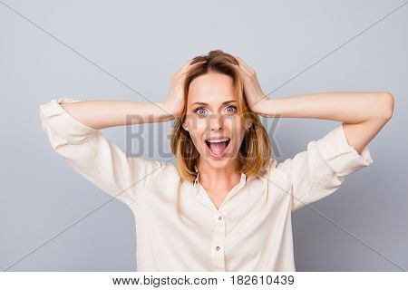 Wow! It's Unbelievable! Shocked Happy Woman With Opened Mouth Touching Her Head Isolated On Gray Bac